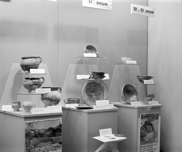 880180 Afbeelding van de in de winter van 1977-1978 tijdens de verbouwing opgegraven voorwerpen in een etalage van het ...